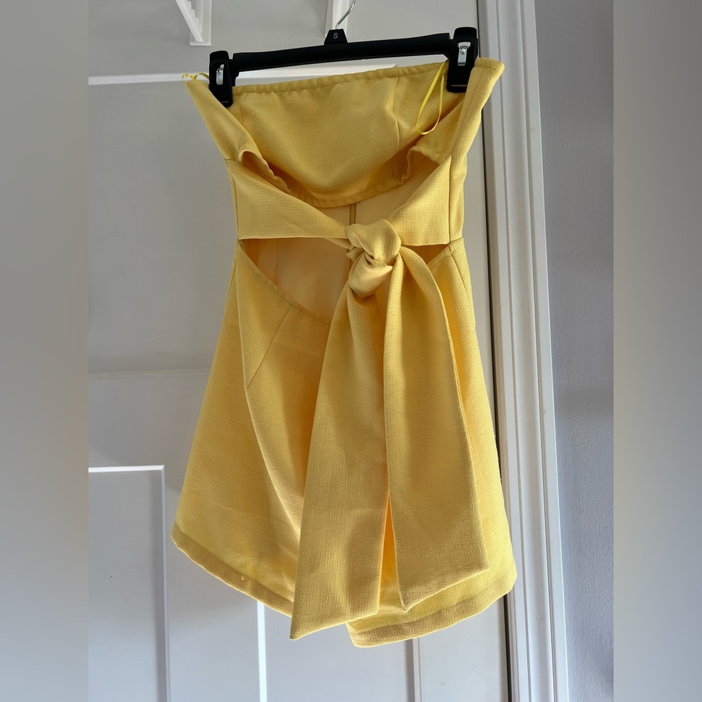 Yellow strapless tie waist romper.